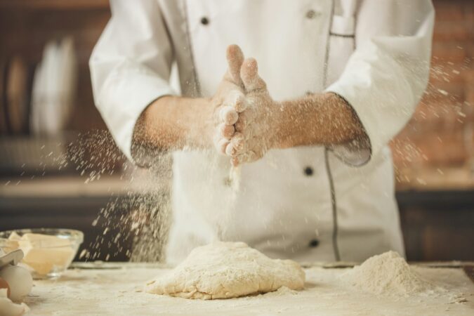 Pizzaiolo con farina tra le mani